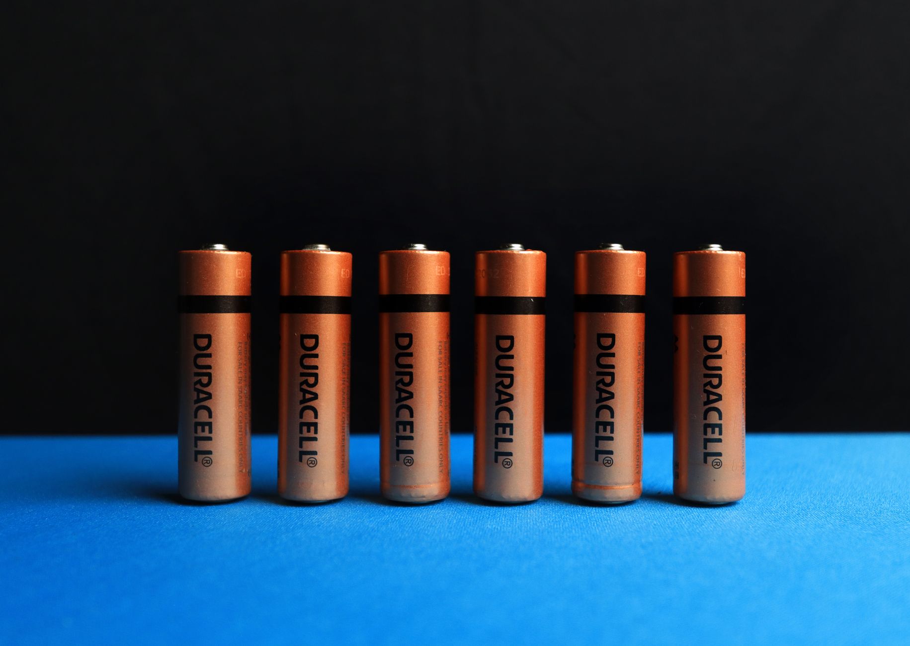 row of batteries on blue surface